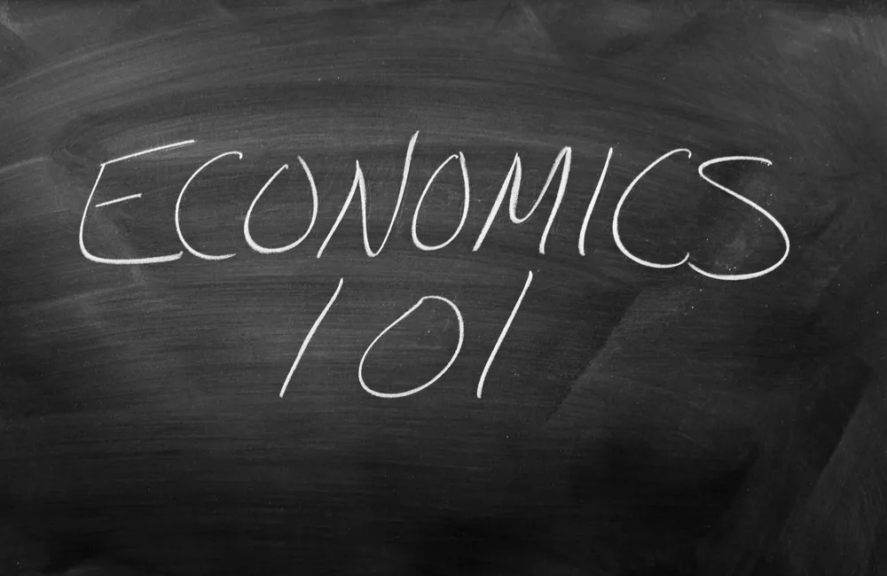 A black chalkboard with the words "Economics 101" written in white chalk.