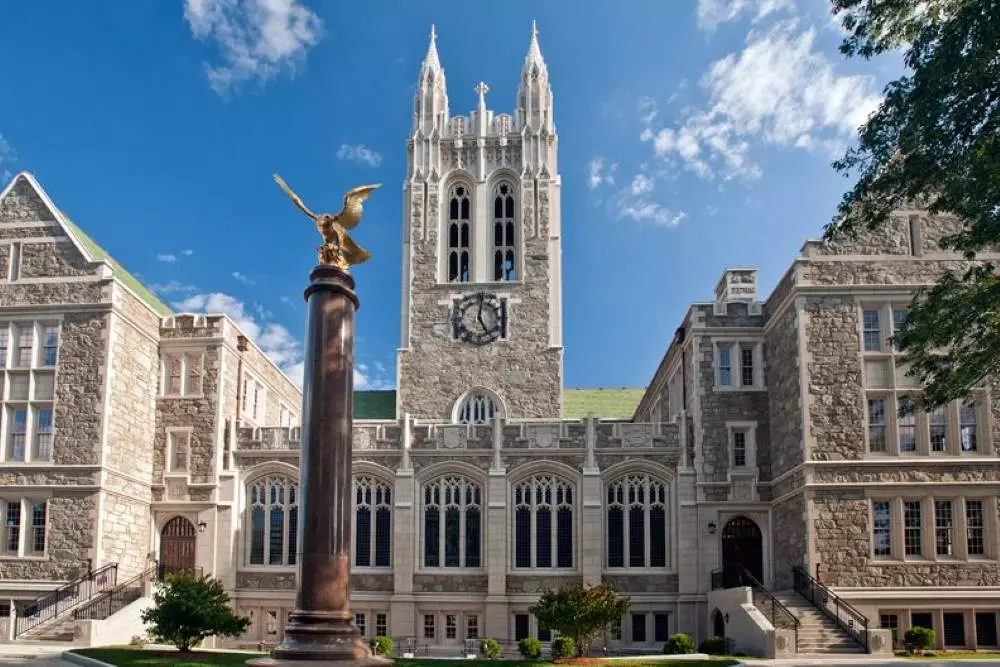 A gold eagle atop a pedestal in front of a building on Boston College's campus.