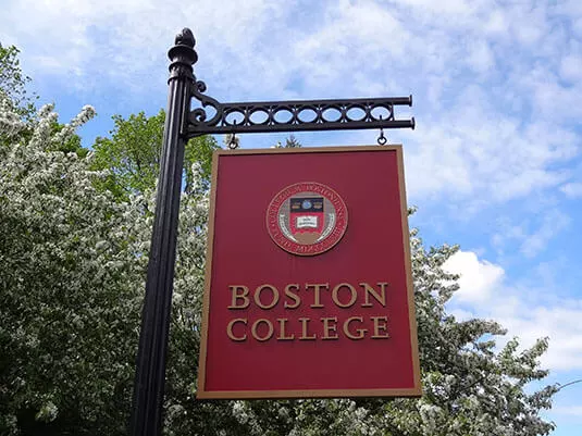 A red Boston College banner against a blue sky.