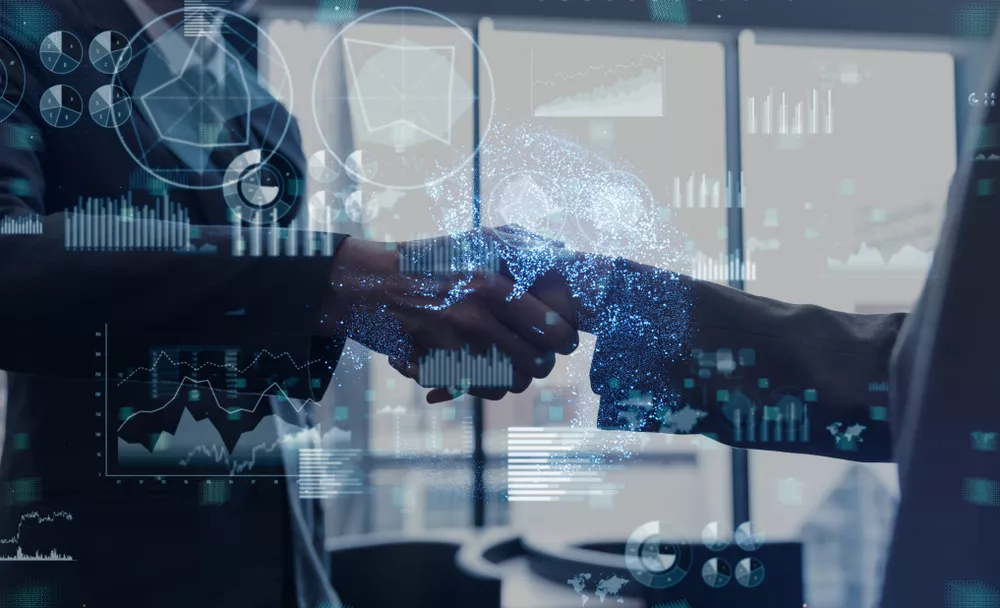 Two people shake hands with an overlay of data and graphs.