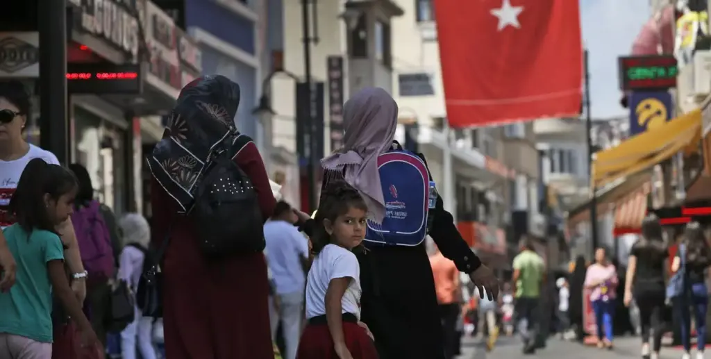 A Turkish flag hangs over a busy street.