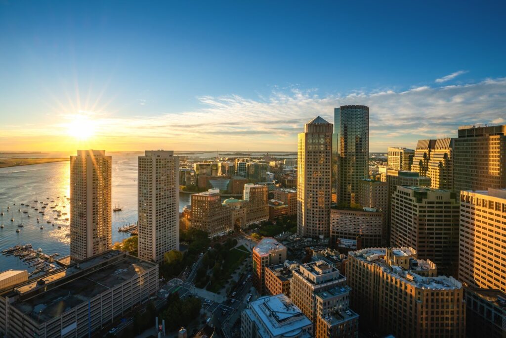 Aerial view of Boston Harbor and the Financial District at sunset.